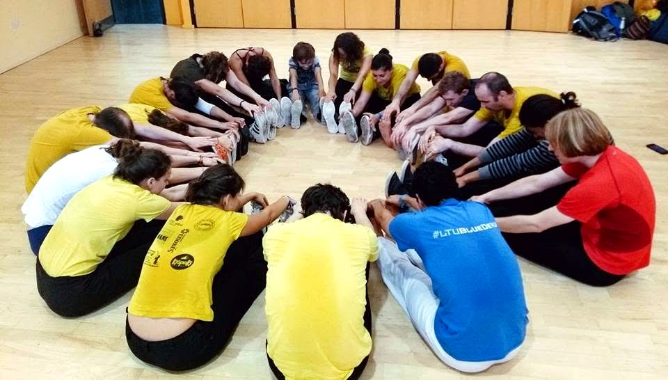Students stretching together in a circle during class