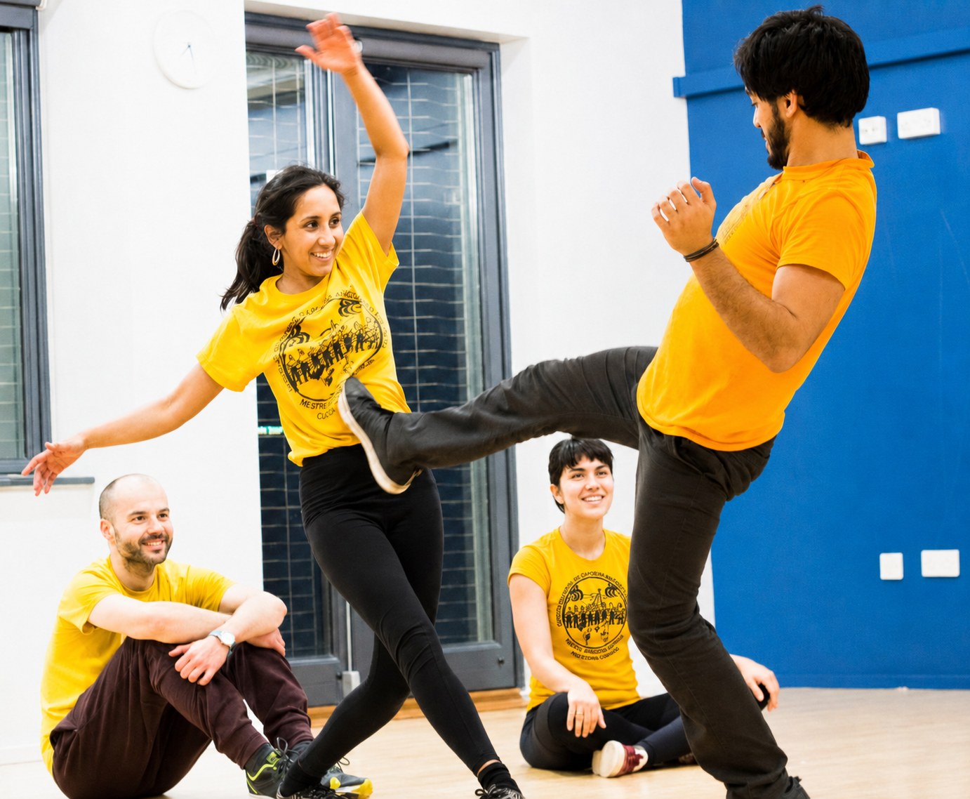 Two Capoeira Angola students playing a close movement game during class